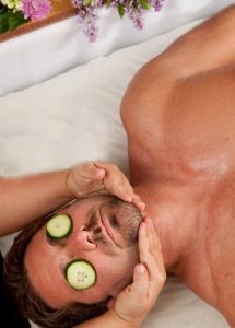 Cucumber on man's eyes to remove fine lines